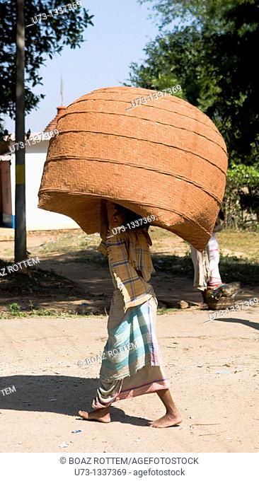 A tribal woman from Orissa carrying a huge basket on her head
