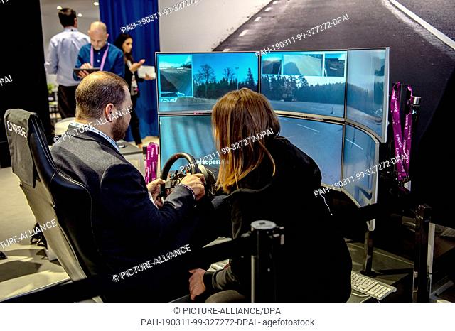 27 February 2019, Spain, Barcelona: A visitor of the mobile radio trade fair Mobile World Congress drives a truck of the company Einride