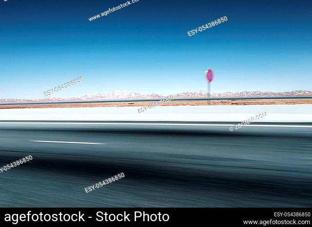 blurred empty asphalt road and snow mountains in blue sky