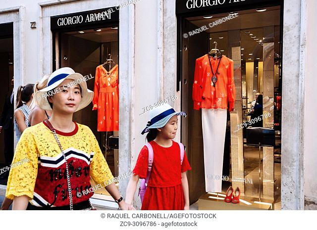 Japanese tourists walking by luxury Georgio Armani store in the area surrounding Piazza di Spagna, Rome, Lazio region, Italy