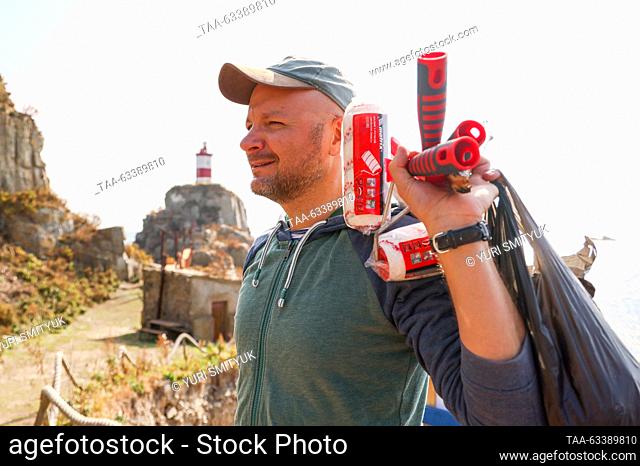 RUSSIA, VLADIVOSTOK - OCTOBER 15, 2023: A volunteer takes part in a clean-up event to collect marine debris by a lighthouse on the Basargin Cape in the Eastern...