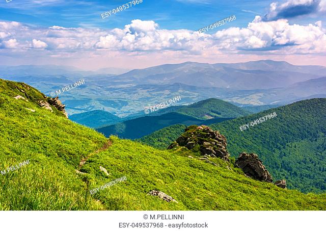 path through grassy hillside over the cliff in mountains. magnificent Borzhava mountain ride in the distance. viewing location mountain Pikui