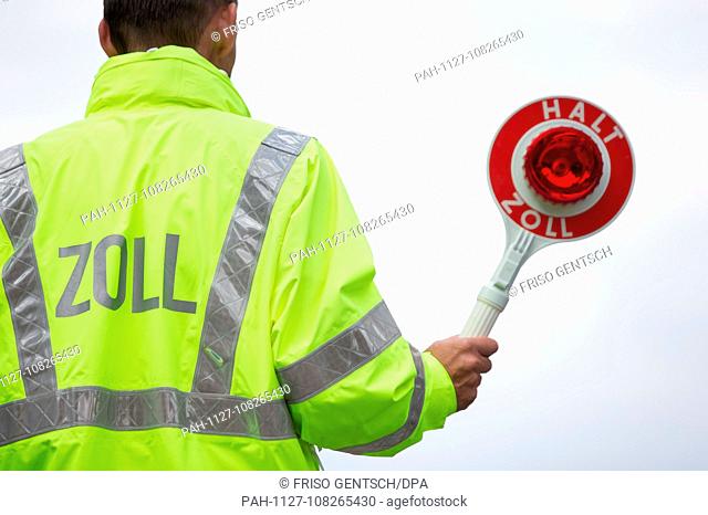 18 July 2018, Germany, Osnabrück: A customs officer holds a trowel ""Halt Zoll"". The preparations of customs for the working conditions changed by the Brexit...