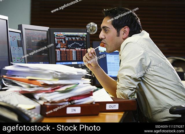 Businessman eating a lollipop at his desk