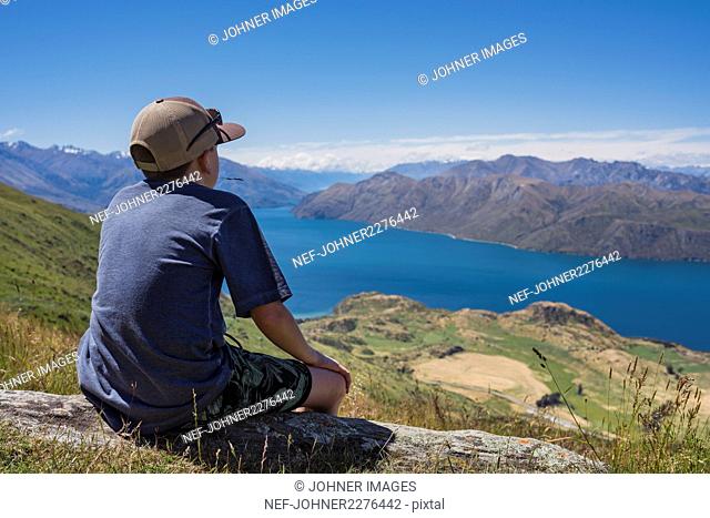Boy looking at lake in mountains