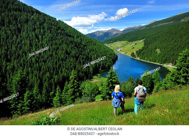 Hikers looking at Durnholz lake, Sarntal Valley, Trentino-Alto Adige, Italy