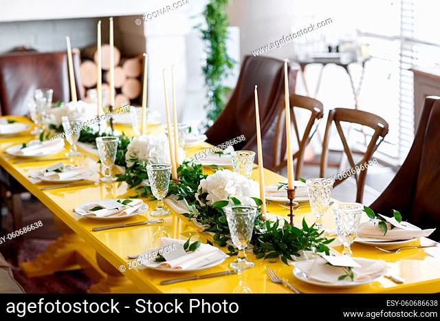 Candles and goblets on a decorated wedding table. yellow green white color. Style lemon
