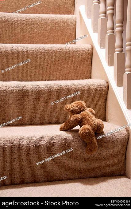 A cute Teddy bear climbing the stairs going to bed