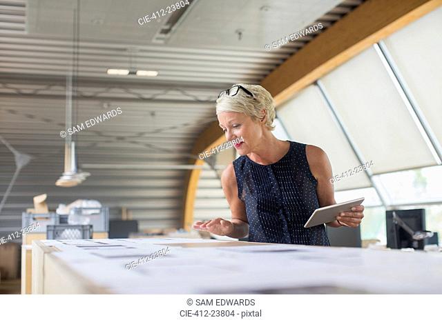 Businesswoman reading paperwork in office