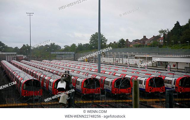 London Underground trains stand idle in the sidings at Stanmore station while officials pickets stand outside the locked gates at East Finchley station