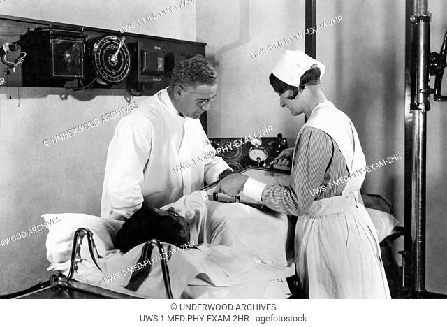 Battle Creek, Michigan: c. 1928.A doctor and nurse performing a fluoroscopic examination of the stomach during the Barium Meal X-Ray Examination at John Harvey...