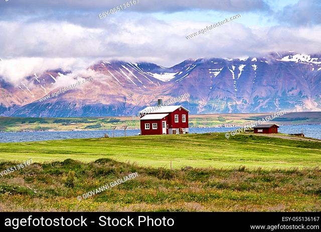 Beautiful red house with mountain landscape in summer season, Iceland