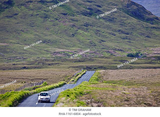 Tourist on Kylemore Pass by the Twelve Bens mountains, Connemara, County Galway, Ireland