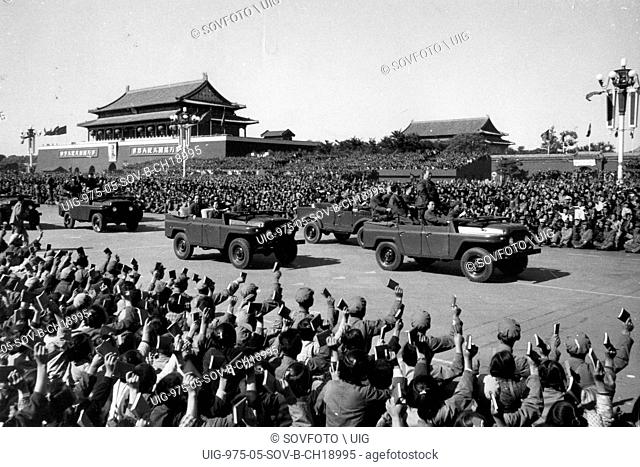 Chairman Mao Zedong driving past a meeting of Red Guards and the revolutionary teachers and students who are holding up copies of his Little Red Book