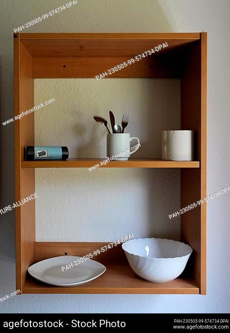 05 May 2023, Berlin: Cutlery and crockery stand on a wooden shelf at the ""Open Day"" of the Berlin Open Prison. In the afternoon