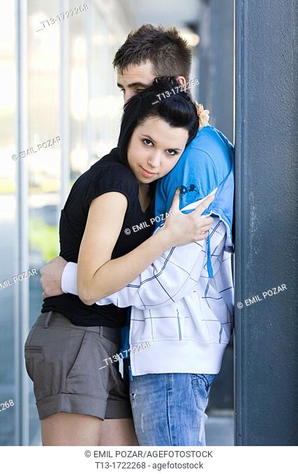 Teen couple hugging in the town