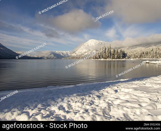 View of the shoreline and the snow-covered forest at Lake Wenatchee State Park in eastern Washington State, USA