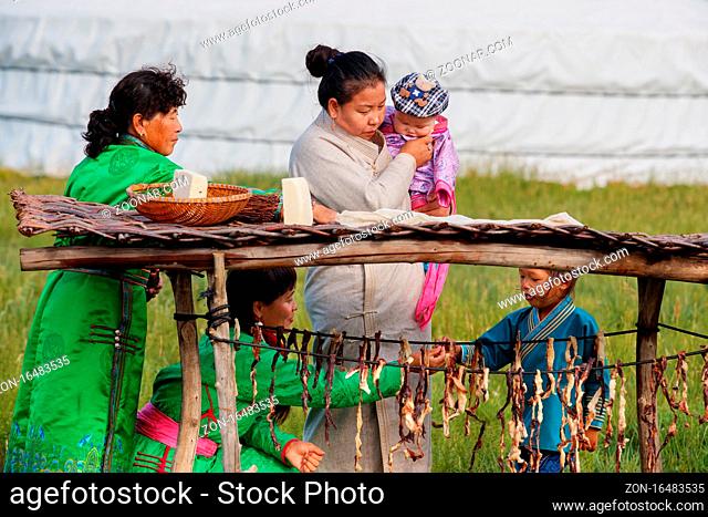 Inner Mongolia, China-July 30, 2017: Nomadic Mongolian family with their traditional colorful dresses near their yurt in immense grassland of the country