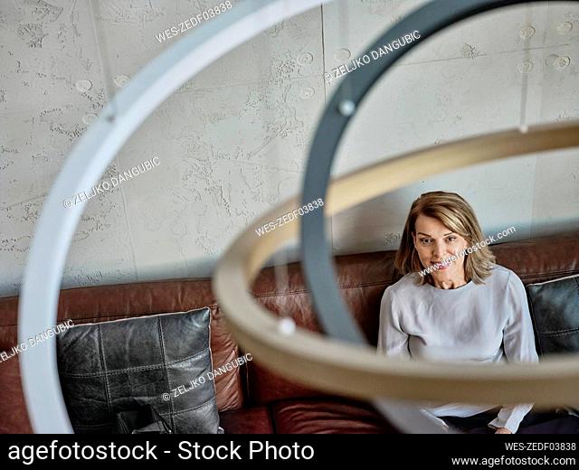 Senior woman looking away while sitting in hotel lobby