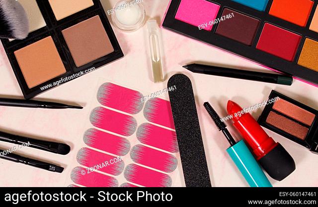 Cosmetics on pink marbled paper background
