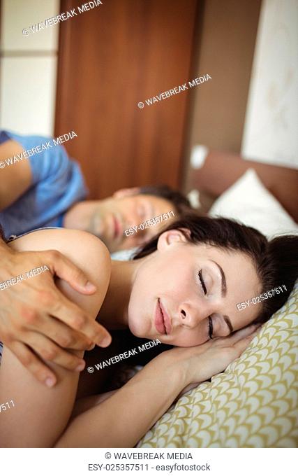 Romantic couple sleeping on bed