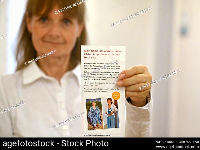 PRODUCTION - 26 September 2023, Berlin: Gabriele Haase, obesity pilot, holds a flyer with her before-and-after picture. Haase advises people who are severely...