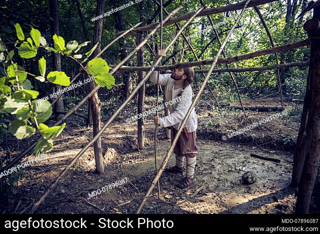 Lombards 6th/7th Century, Italy, Friuli Venezia Giulia:daily duties. Building the plot for the hazelnut branches structure that will be covered in clay and...