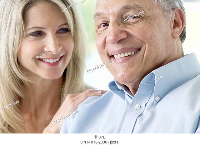 Senior man and mature woman smiling towards camera