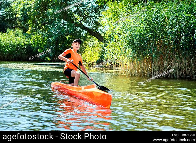 The boy rowing in a canoe on the river. action scenes