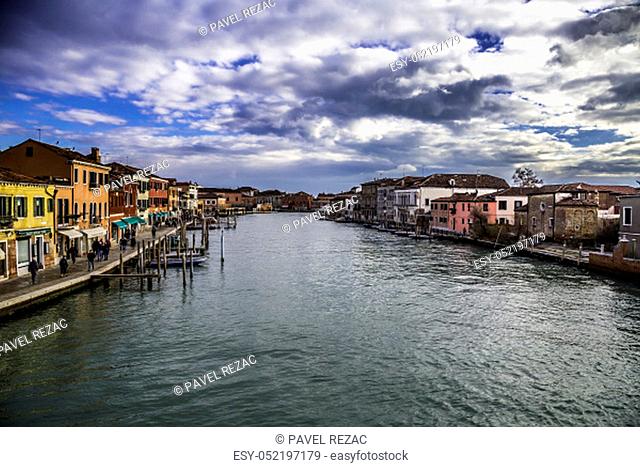 The picturesque island of Murano in the Venetian Lagoon is interwoven with canals and narrow streets between historic houses and palaces with beautiful gardens