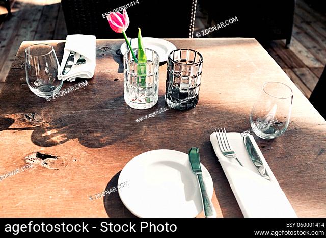 table setting for a lovey dinner. Empty glasses set in restaurant. Part of interior. napkins, plates, and eating utensils