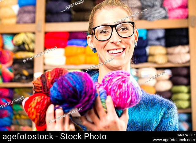 Young woman buying colorful wool and yarn for their hobby in a knitting shop