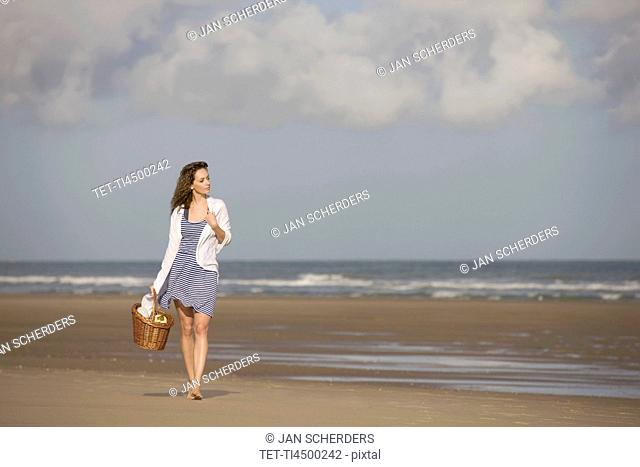 France, Pas-de-Calais, Escalles, Young woman strolling on empty beach