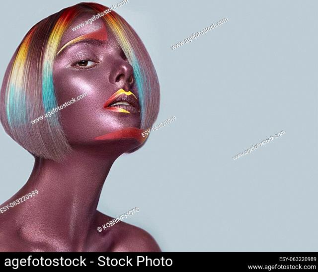 Beautiful girl with multi-colored hair and creative make up and hairstyle. Beauty face. Photo taken in the studio