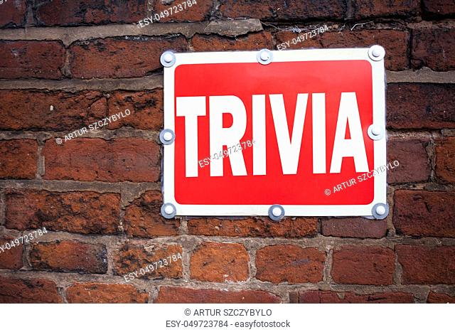 Hand writing text caption inspiration showing Trivia concept meaning Unimportant Quiz Fun written on old announcement road sign with background and space