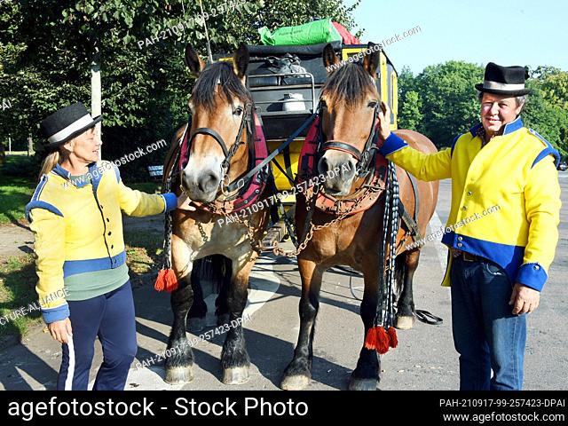 14 September 2021, Saxony, Leipzig: The coachman Siegfried Händler and his sister and helper Kerstin Händler stand with the cold-blooded horses ""Evi"" and...