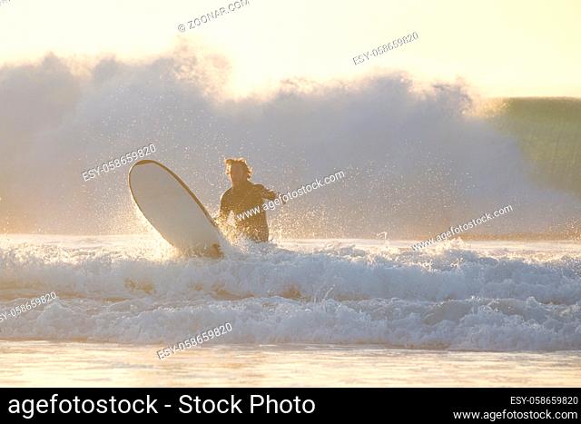 EL Cotillo, Spain - Dec 22, 2015: Surfer beginner learnig to surf at El Cotillo beach, famous surfing destination on Fuerteventura, Canary Islands