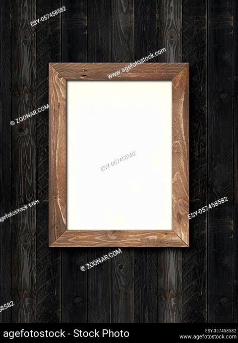 Old rustic wooden picture frame hanging on a black wood wall. Horizontal picture. Blank mockup template