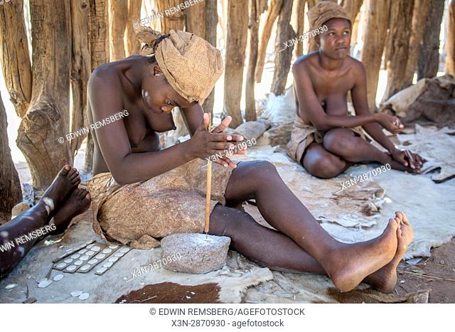Damaran women making buttons out of bone at the Damara Living Museum, located north of Twyfelfontein in Namibia, Africa