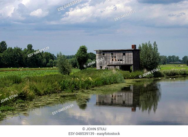 Run-down shed on the bank of the river Giessen near Hoornaar in the Dutch region Alblasserwaard