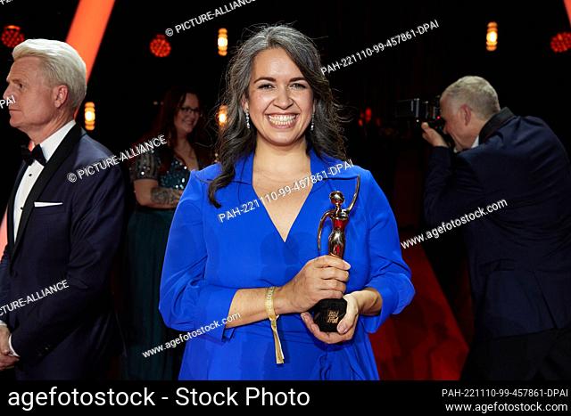 09 November 2022, Hamburg: Award winner Günes Seyfarth, Community Kitchen gGmbH, stands on stage with her trophy at the Stage Theater Neue Flora after receiving...