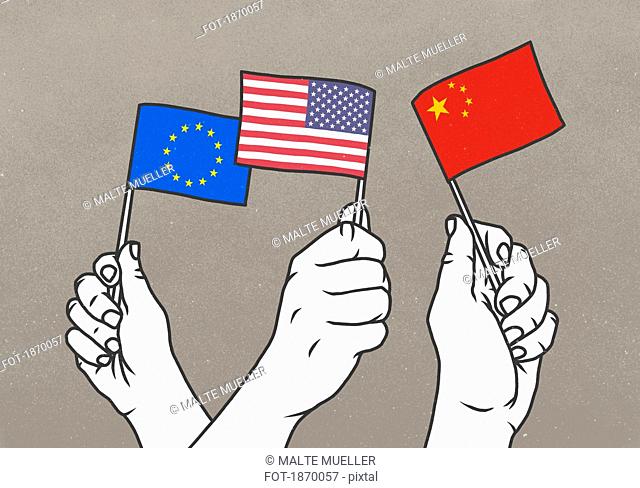 Hands waving small European Union, American and Chinese flags