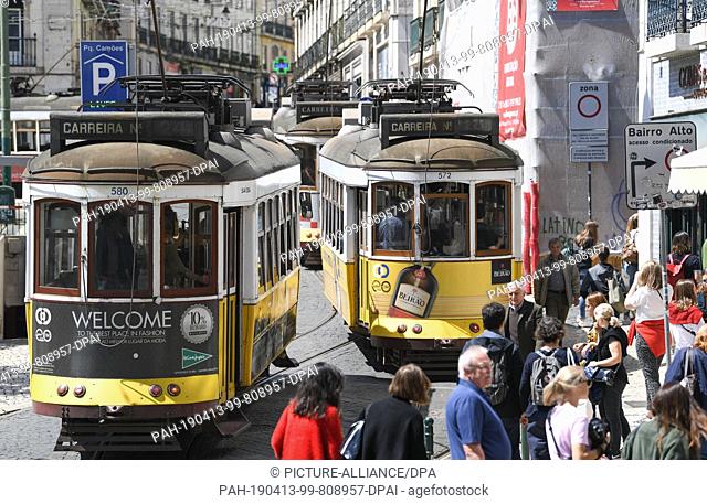 12 April 2019, Portugal, Lissabon: Trams number 24 (l) and 28 go through Praca Luis de Comoes. The central square in the centre of Lisbon connects the districts...