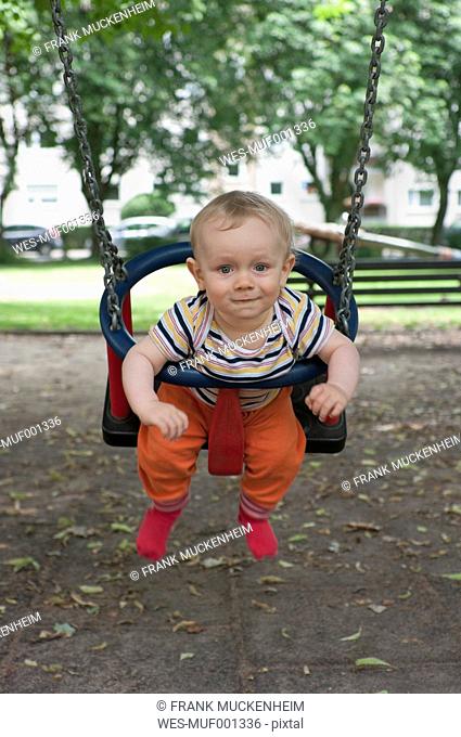 Germany, Hesse, Frankfurt, Portrait of baby boy swinging