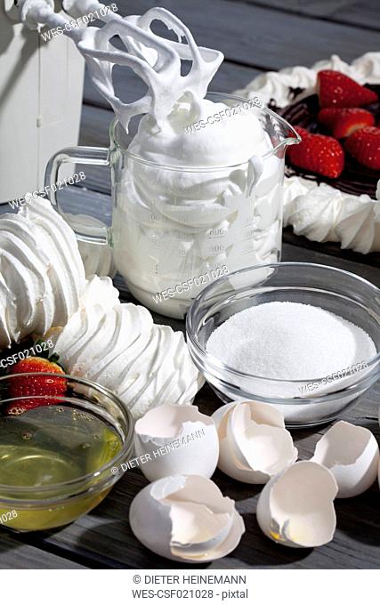 Meringues, measuring cup of beaten egg white and ingredients for meringue