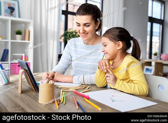 mother and daughter with tablet pc drawing at home