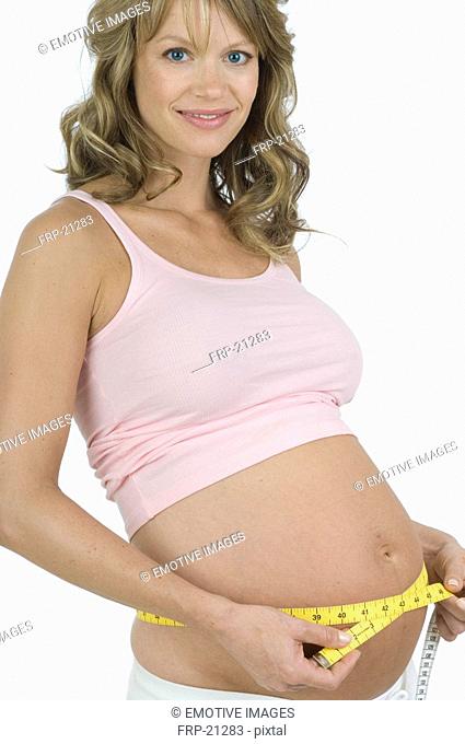 Pregnant woman measuring her waist