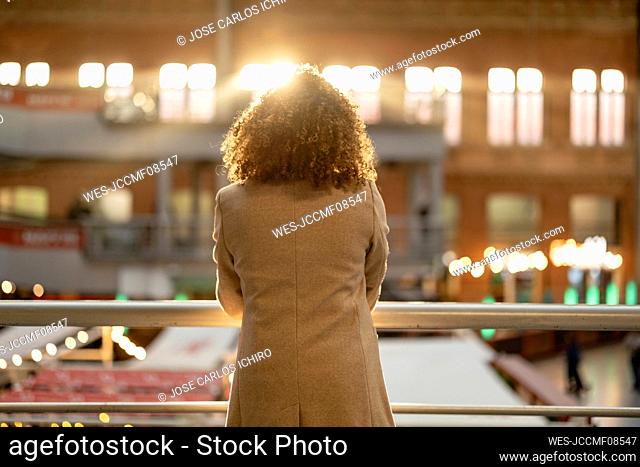 Woman with curly hair in front of railing