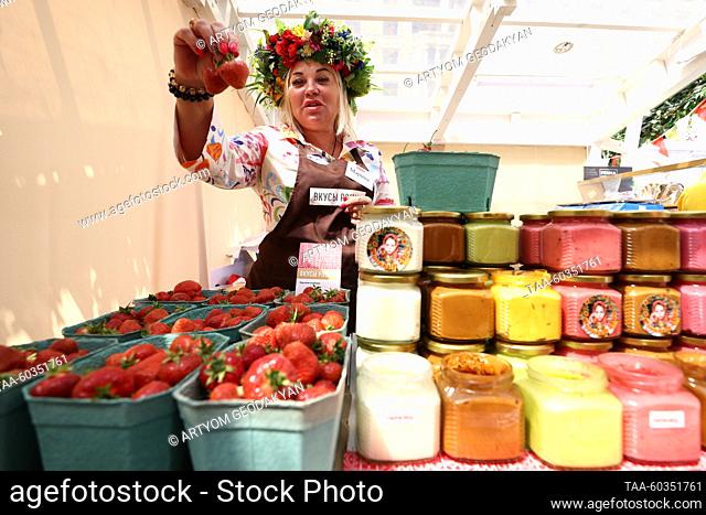 RUSSIA, MOSCOW - JULY 9, 2023: A woman holds strawberries during the Tastes of Russia food festival in Manezhnaya Square