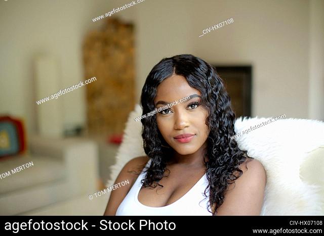 Portrait beautiful young woman with black curly hair in living room
